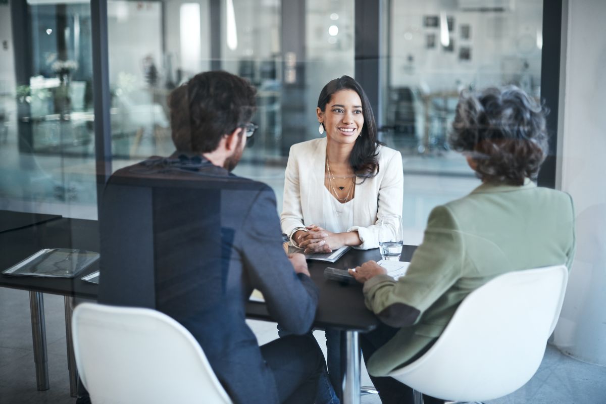 Two employees sit and discuss benefits with their HR rep.