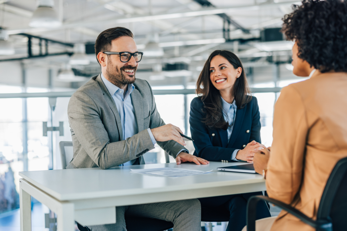 A business owner and colleagues sit around a table reflecting, celebrating, and expressing gratitude.