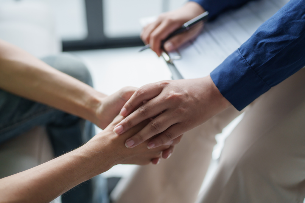 two people holding hands with a cllipboard and paper